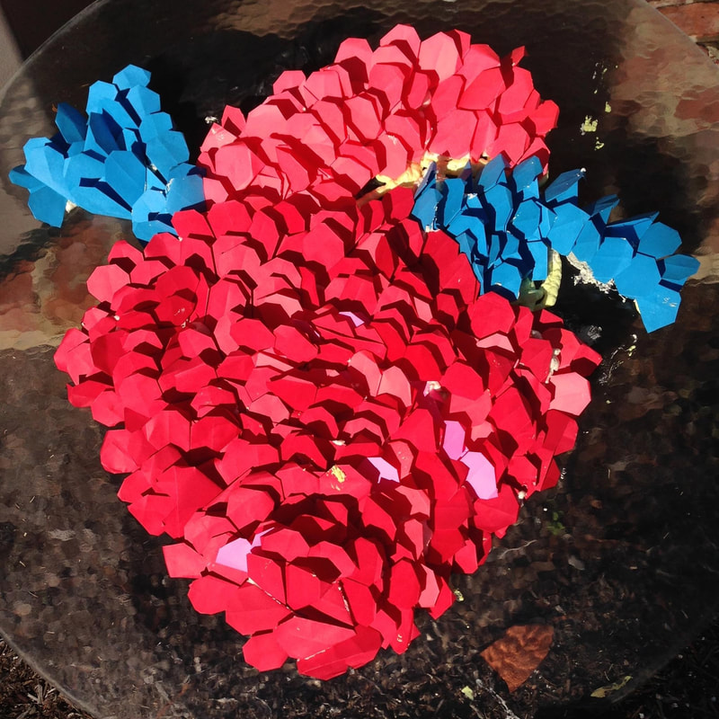 Pink and blue colored heart made of origami hearts